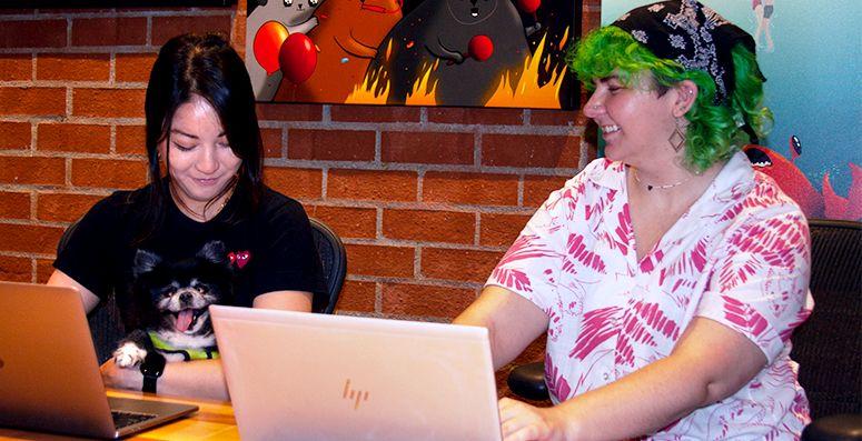 Two coworkers working together at a laptop