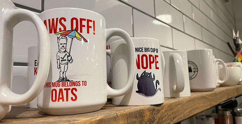 Row of mugs printed with funny cat sayings