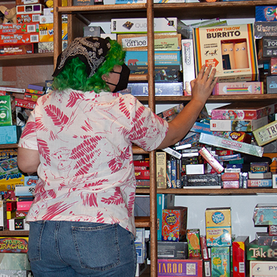 Person in a cat mask excited at a game store shelf