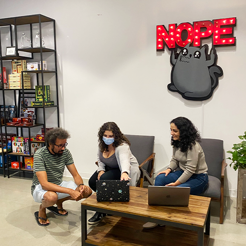 Exploding Kittens team in an office with a Nope cat sign, 2021 