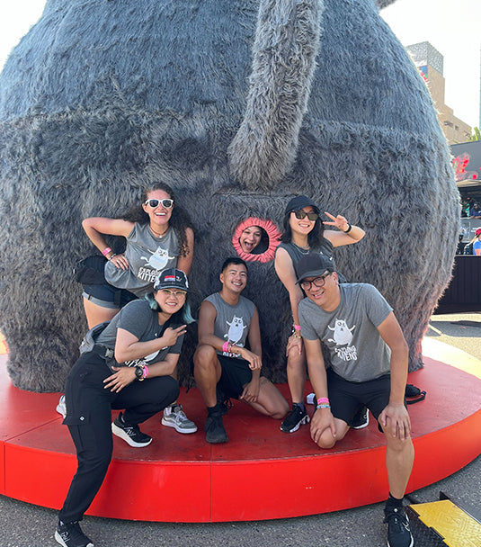 Group of people posing on a giant inflatable cat at an event 