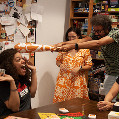 People at a table playing with a foam burrito 